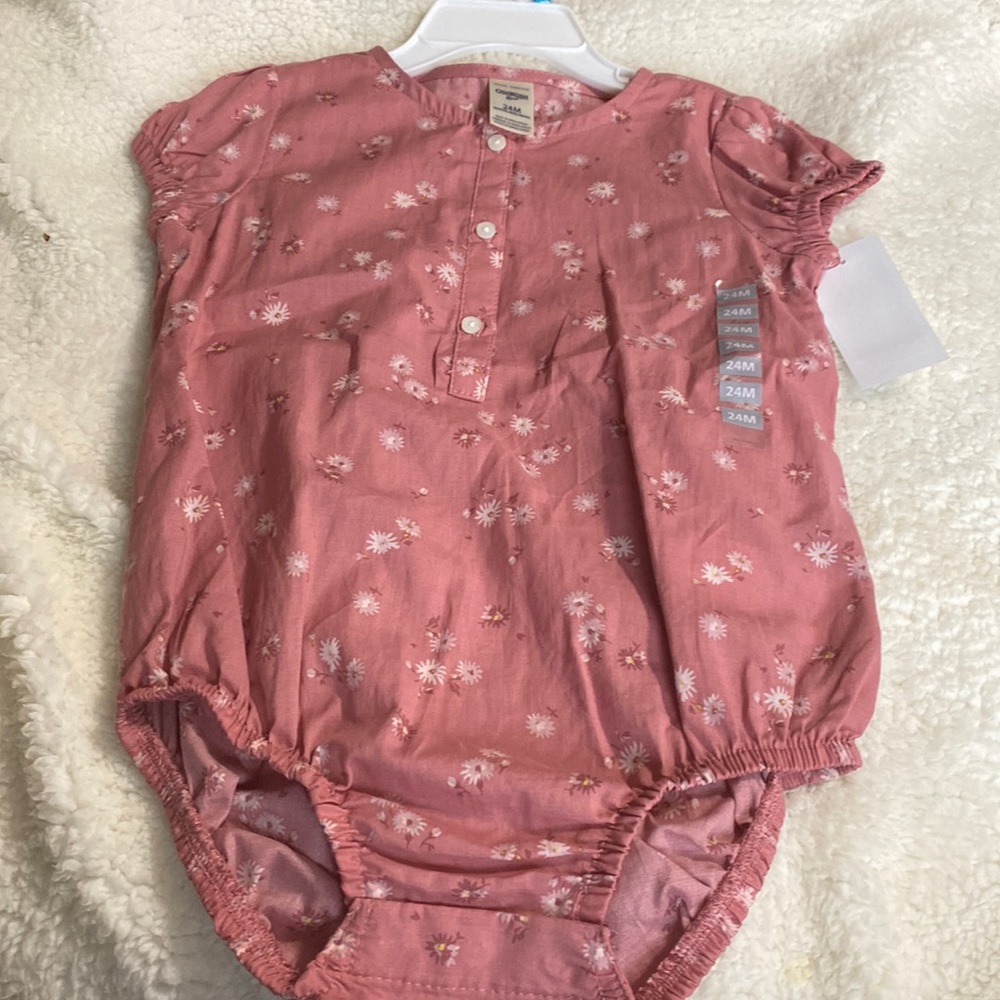Mauve shirt with snaps at the bottom and flowers on it